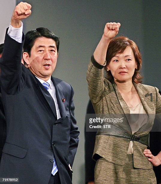 In this photo taken 12 August 2006 shows Japanese Chief Cabinet Secretary Shinzo Abe and his wife Akie raise clinched fists during a campaign for the...
