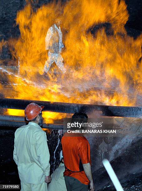 Pakistani fire-fighters extinguish a burning gas pipeline near Quetta, late 23 September 2006. Insurgents blew up a natural gas pipeline in the...