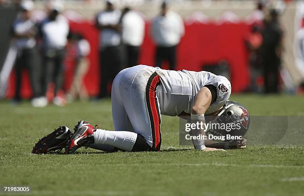 Quarterback Chris Simms of the Tampa Bay Buccaneers doubles over in pain after being hit by defensive end Al Wallace of the Carolina Panthers in the...