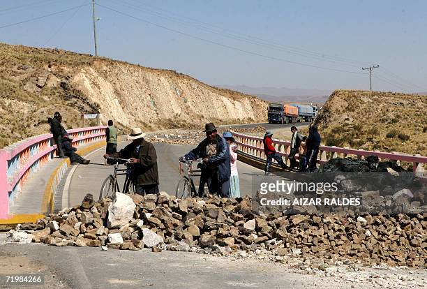 Aymaras transitan en bicicleta por un puente bloqueado con piedras en la carretera que une la poblacion fronteriza de Desaguadero en Peru, cerca de...