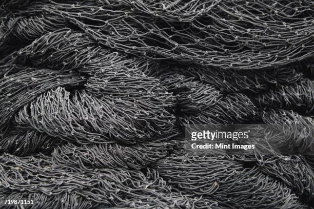 close up of a pile of tangled up commercial fishing nets. - kommersiellt fisknät bildbanksfoton och bilder