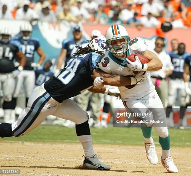 Wide Receiver Wes Welker of the Miami Dolphins being tackled by Lamont Thompson of the Tennessee Titans at Dolphins Stadium on September 24, 2006 in...