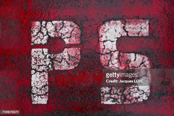 ps stencilled in white letters on a red background, injured by age and bad weather (mountain) - socialist party stockfoto's en -beelden