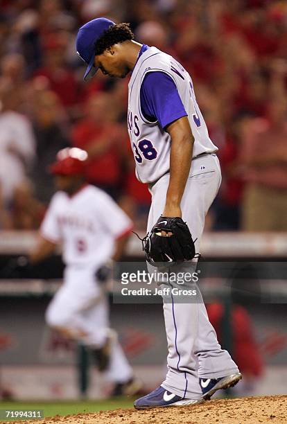 Edinson Volquez of the Texas Rangers looks down after giving up a solo home run to Chone Figgins of the Los Angeles Angels of Anaheim in the fourth...