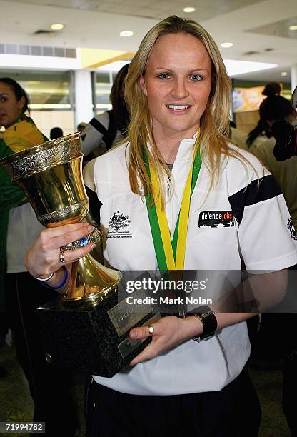 Jenni Screen of the Australian Opals basketball team poses with the World Championship trophy as the team arrived at Sydney Airport on September 26,...