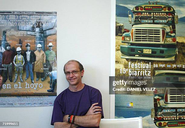 Mexican director Juan Carlos Rulfo poses in front of the poster of his movie "En el hoyo" that will be screened, 26 September 2006 in Biarritz...