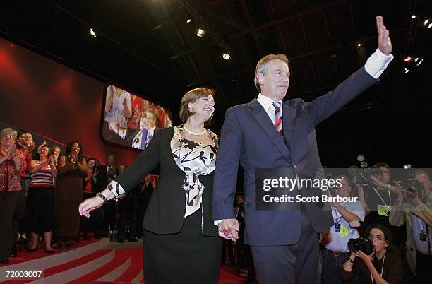 Britain's Prime Minister Tony Blair and his wife Cherie wave to the audience after Tony delivered his keynote speech during the Labour Party Autumn...