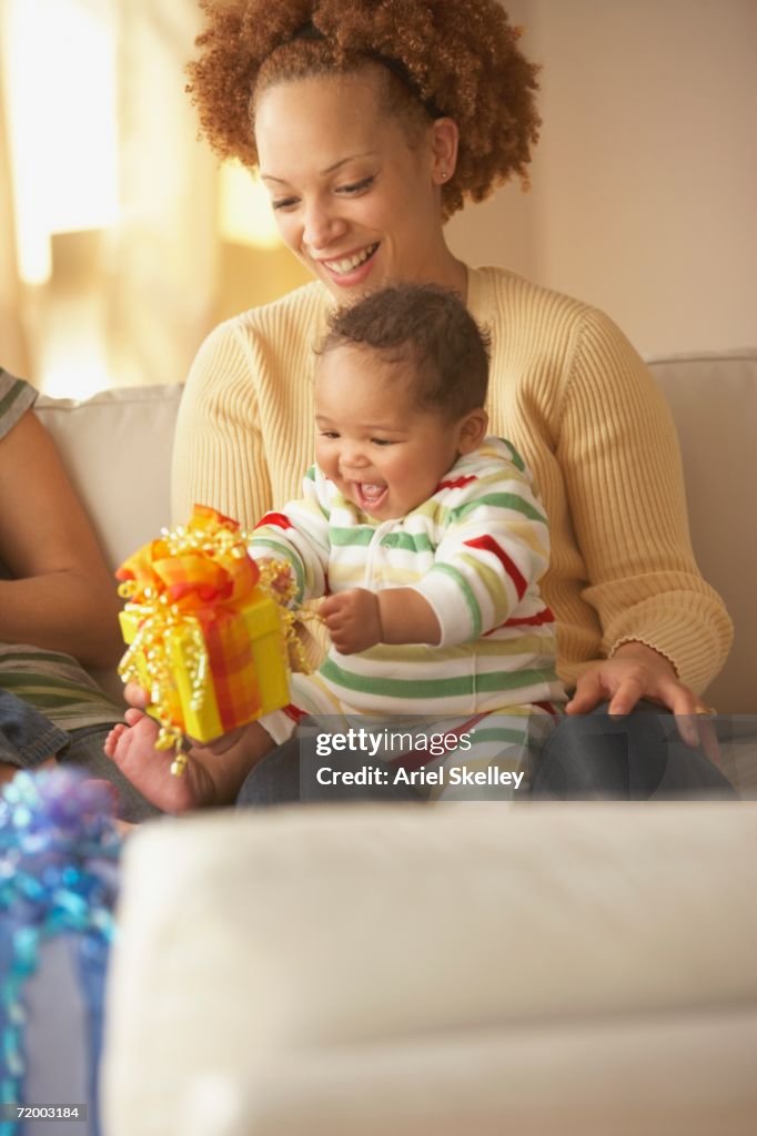 African mother holding baby and gift