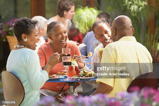 group of middle-aged friends at outdoor restaurant - african dining stock pictures, royalty-free photos & images