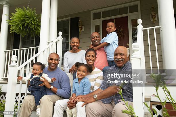 multi-generational african family smiling on porch - black family reunion stock pictures, royalty-free photos & images