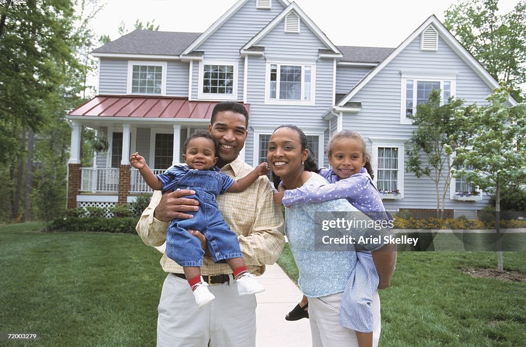 African family smiling in front of house