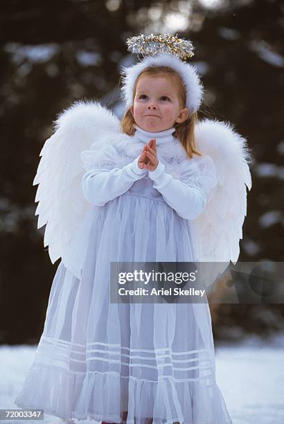 girl in angel costume outdoors - kerstkind stockfoto's en -beelden