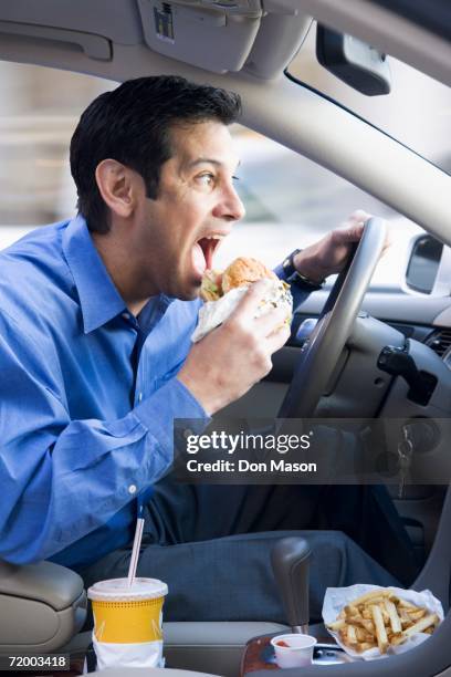 hispanic businessman eating and driving - distraído imagens e fotografias de stock