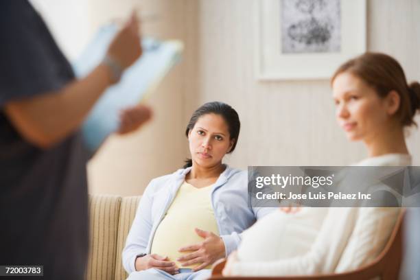 pregnant women in waiting room - pregnancy class stock-fotos und bilder