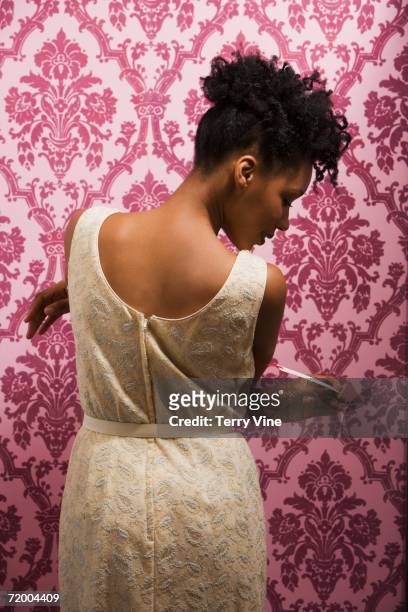 african woman trying on dress and looking at price tag - tag 1 ストックフォトと画像