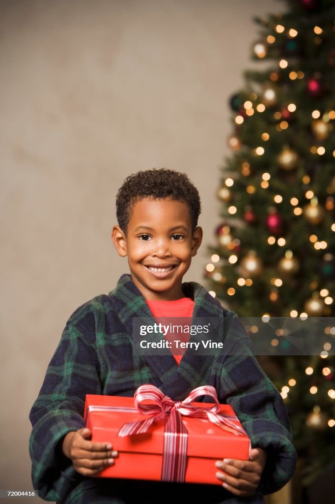 African boy smiling and holding Christmas gift