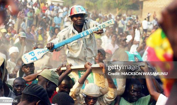 Supporters of Zambian opposition Patriotic Front leader Michael Sata carry a man in a bathtub, the party's symbol, during a rally 26 September 2006...