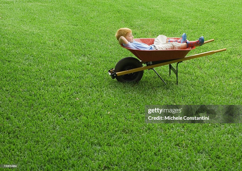 Boy sleeping in wheelbarrow