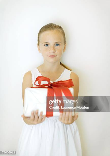 girl holding present, front view - freckle girl foto e immagini stock