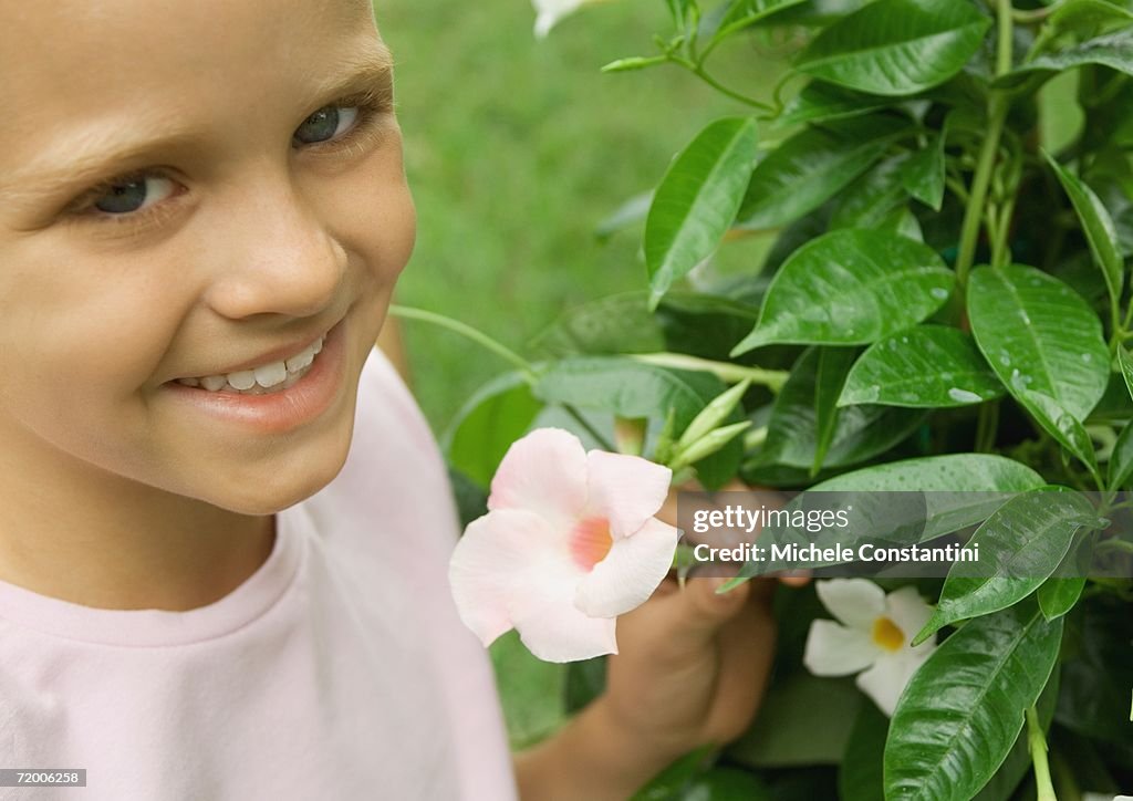 Girl next to mandevilla plant