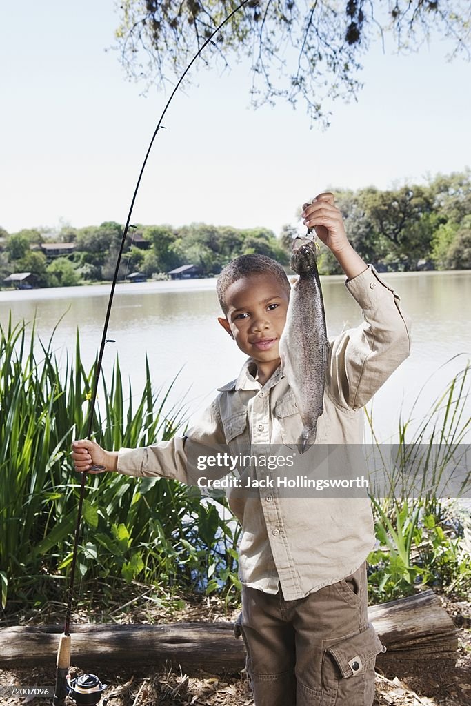 Young African boy with fishing pole and fish