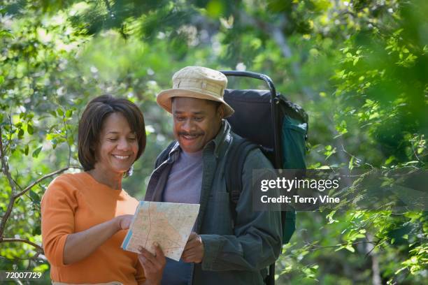 african couple hiking with map in woods - terry woods ストックフォトと画像