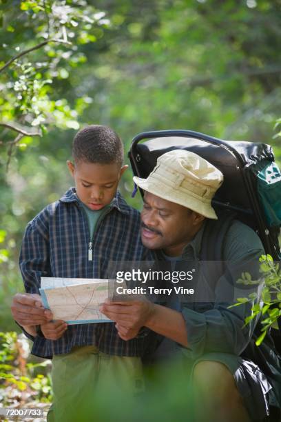 african father and son with map in woods - terry woods stock pictures, royalty-free photos & images