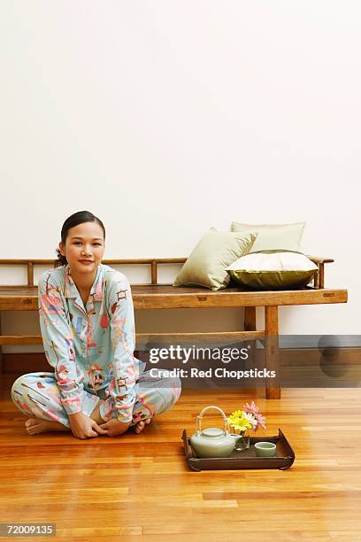 portrait of a young woman sitting on a hardwood floor - bare feet on hardwood stock pictures, royalty-free photos & images