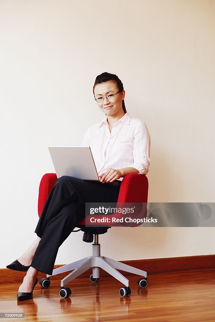 Businesswoman using a laptop and smiling