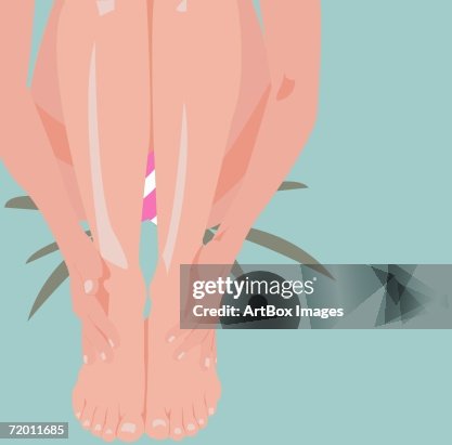 Low section view of a woman massaging her feet Low section view of a woman massaging her feet