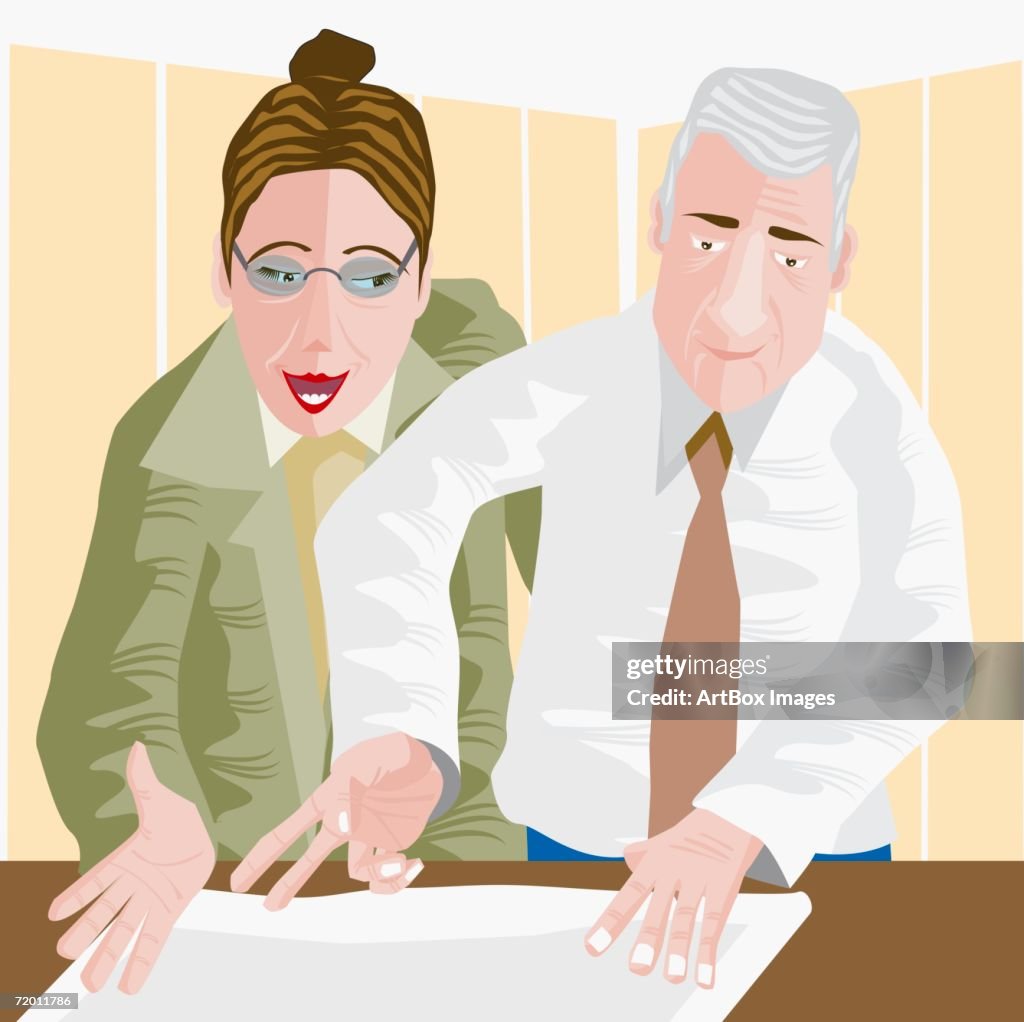 Close-up of a businessman and a businesswoman discussing a blueprint