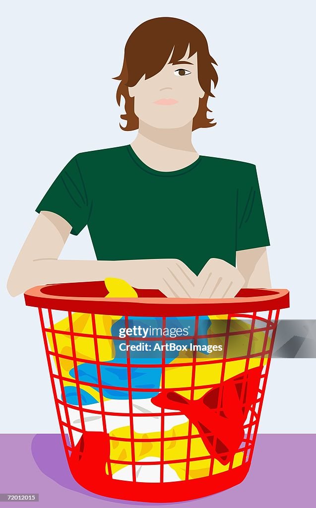 Portrait of a young man holding a laundry basket