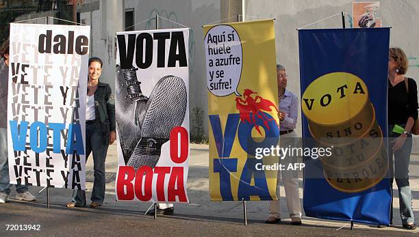 Un grupo de opositores al gobierno del presidente venezolano Hugo Chavez sostienen carteles alusivos, en Caracas el 26 de setiembre de 2006, al...