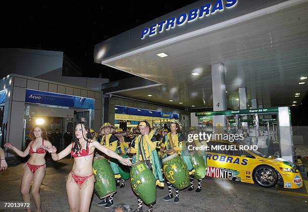 Una tipica "cuerda de tambores" con sus bailarinas actua durante la inauguracion de una de las 89 estaciones de servicio adquiridas por la estatal...