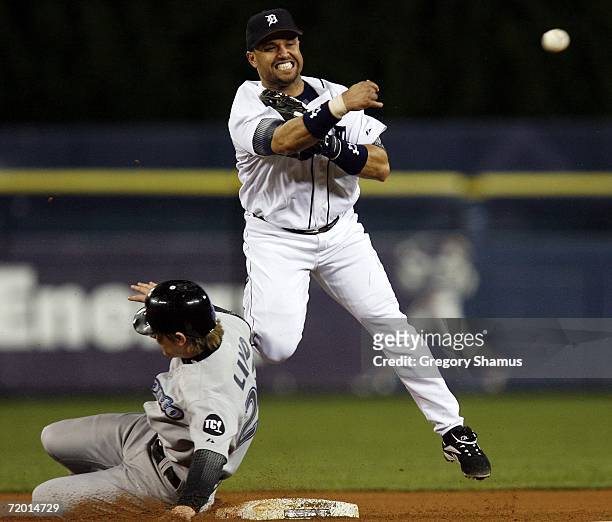 Placido Polanco of the Detroit Tigers turns a double play behind the slide of Adam Lind of the Toronto Blue Jays on September 26, 2006 at Comerica...