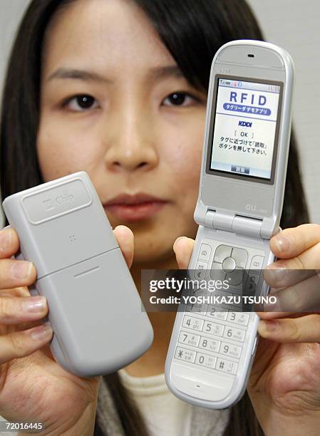Hitachi employee displays a radio frequency identification tag reader which attaches to the base of the Hitachi mobile phone, in Tokyo 27 September...