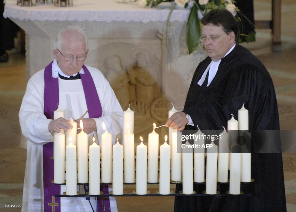 A Protestant priest and a Catholic priest light candles during an ...