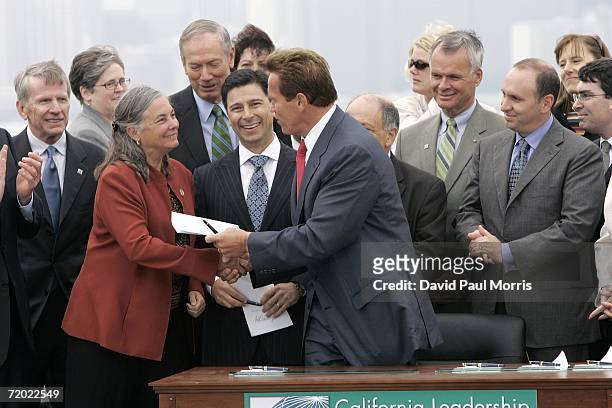California Governor Arnold Schwarzenegger hands Assembly member Fran Pavley a copy of his signed bill AB-32, the California Global Warming Solutions...