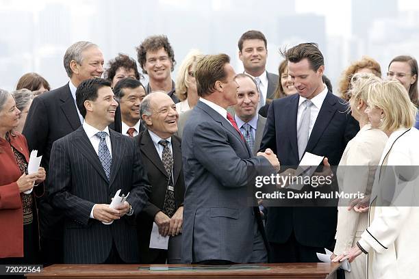 California Governor Arnold Schwarzenegger hands San Francisco Mayor Gavin Newsom a copy of his signed bill AB-32, the California Global Warming...