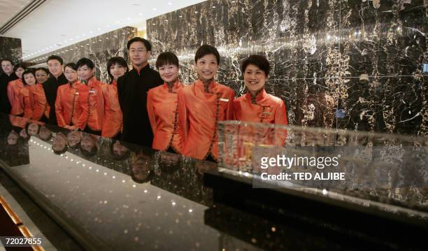 Employees pose for a photo during the ribbon-cutting ceremony on the occasion of the re-opening of the Mandarin hotel in Hong Kong, 28 September...