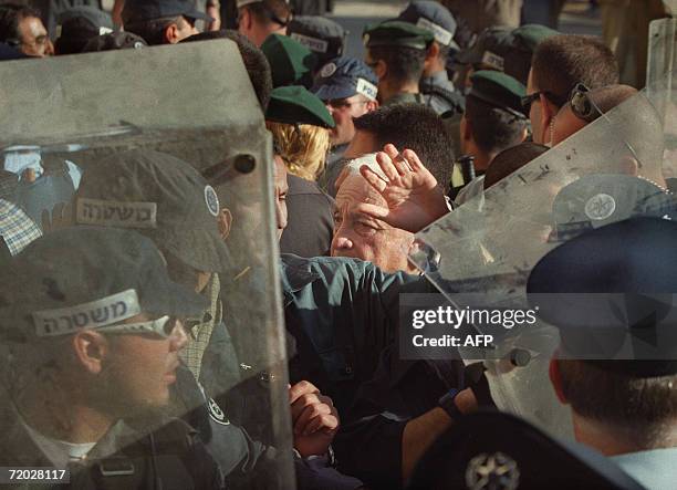 --Israeli right-wing opposition leader Ariel Sharon is flanked by security guards as he leaves the Al-Aqsa mosque compound in Jerusalem's Old City 28...