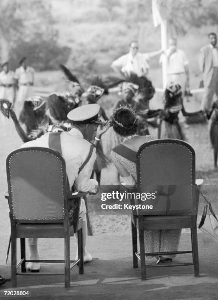 Queen Elizabeth II and Prince Philip are entertained by traditional Susu dancers during an official visit to Port Loko, Sierra Leone, 4th December...