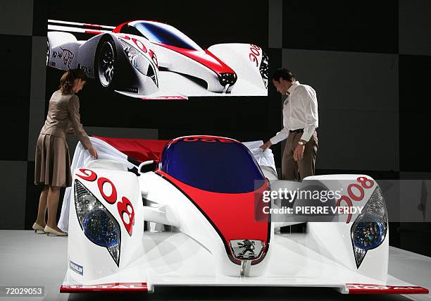 French car maker Peugeot's staff members present the Peugeot 908 racing car during the press days at the Paris Motor Show 28 September 2006. Over the...