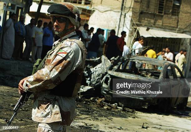 An Iraqi soldier stands guard at the scene of a car bomb explosion on September 28, 2006 in Baghdad, Iraq. A car bomb exploded targeting a police...