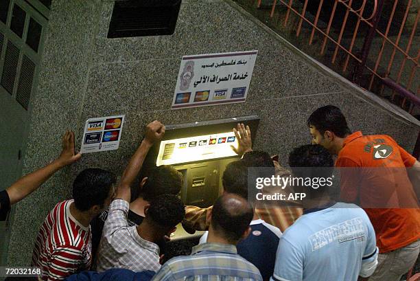 Palestinian civil servant queue at an electronic cash point machine in the West Bank city of Ramallah 28 September 2006. Palestinian civil servants...