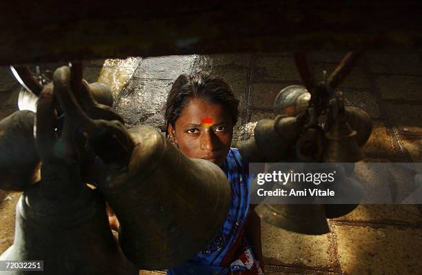 Yellama rings bells in a temple dedicated to Yellam as she prepares to worship the goddess she has been named after August 23, 2005 in Mehbubnagar,...