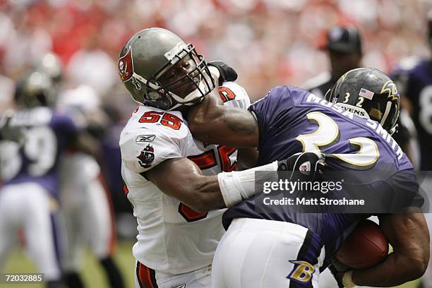 Linebacker Derrick Brooks of the Tampa Bay Buccaneers tries to stop running back Musa Smith of the Baltimore Ravens during their NFL game on...