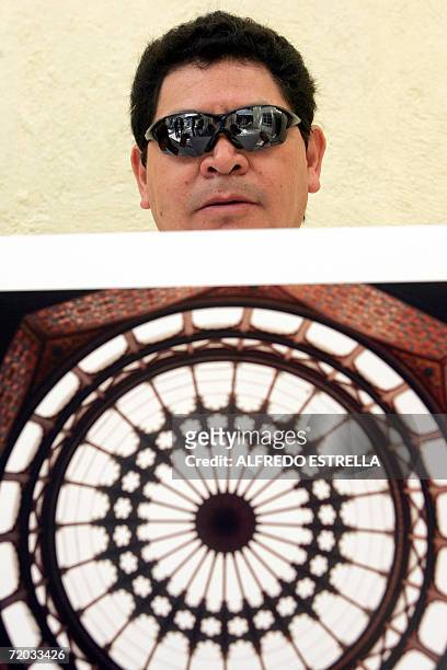 Jaime Vega, fotografo ciego, muestra una fotografia tomada por el durante una entrevista con la AFP en la fundacion de ayuda para ciegos "Ojos Que...