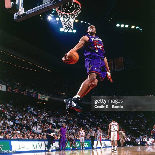 Vince Carter of the Toronto Raptors elevates for a spectacular slam dunk against the Houston Rockets during a 1999 NBA game at the Summit in Houston,...