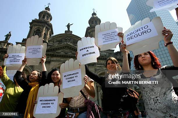 Mujeres pertenecientes a movimientos femeninos sostienen carteles a favor del aborto frente a la catedral de la ciudad de Santiago, el 28 de...